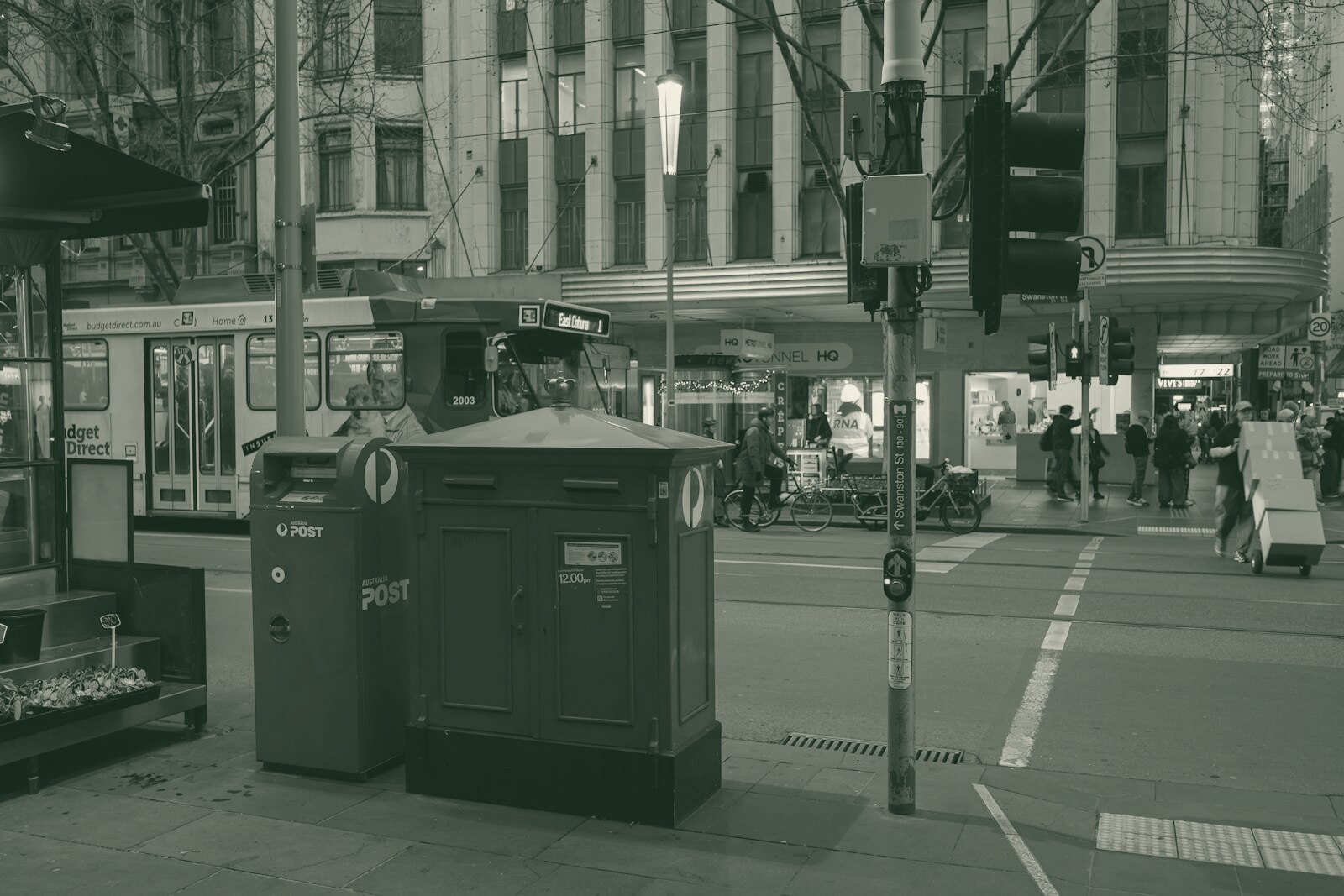 A red trash can sitting on the side of a road