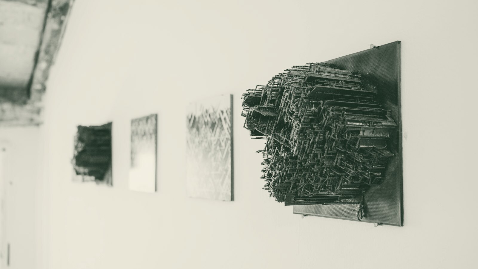 a white wall with black artwork hanging on it